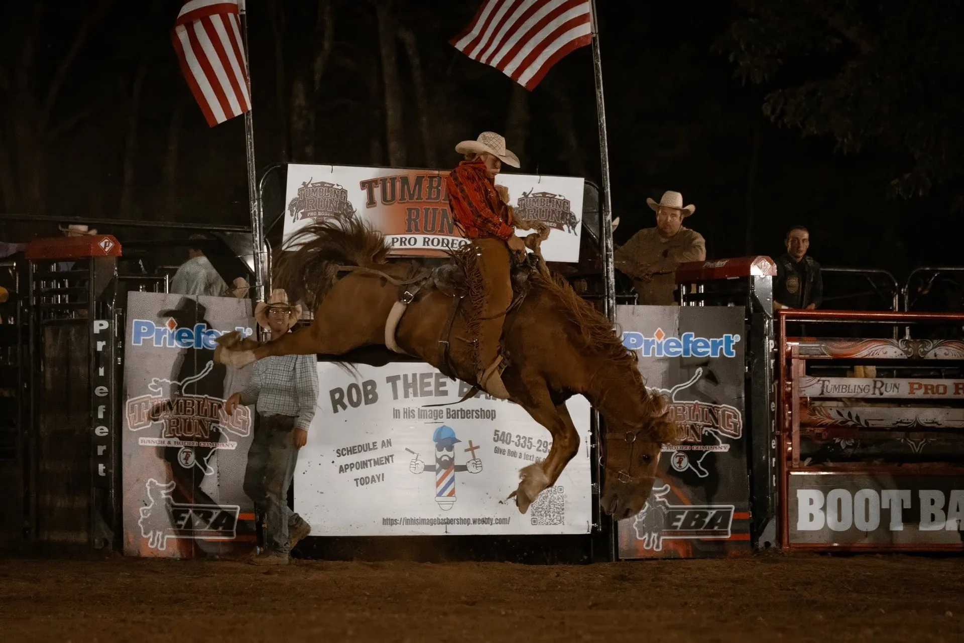Bucking horse and rider under arena lights